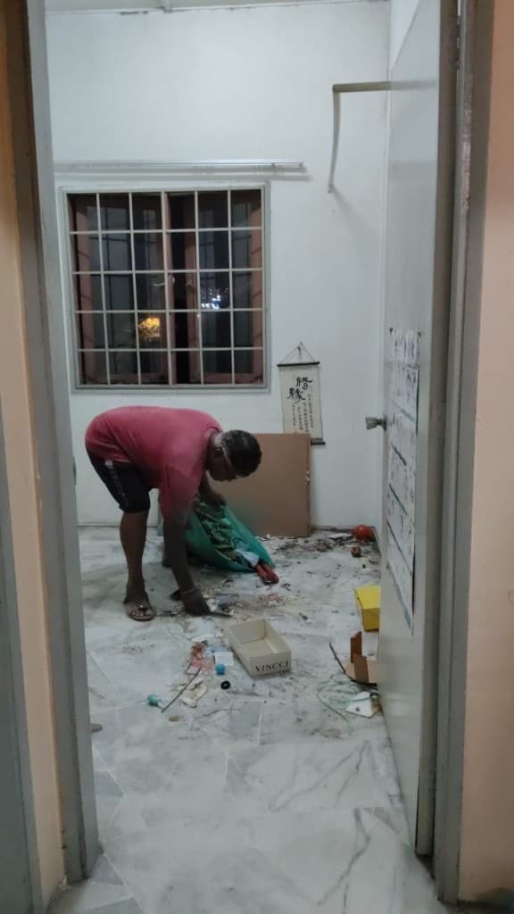 Crew member bagging small debris during apartment clear-out